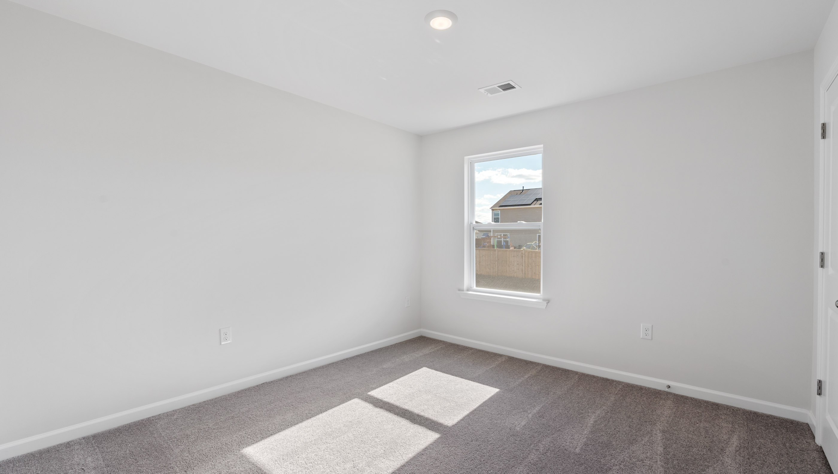 Bedroom with carpet and windows.