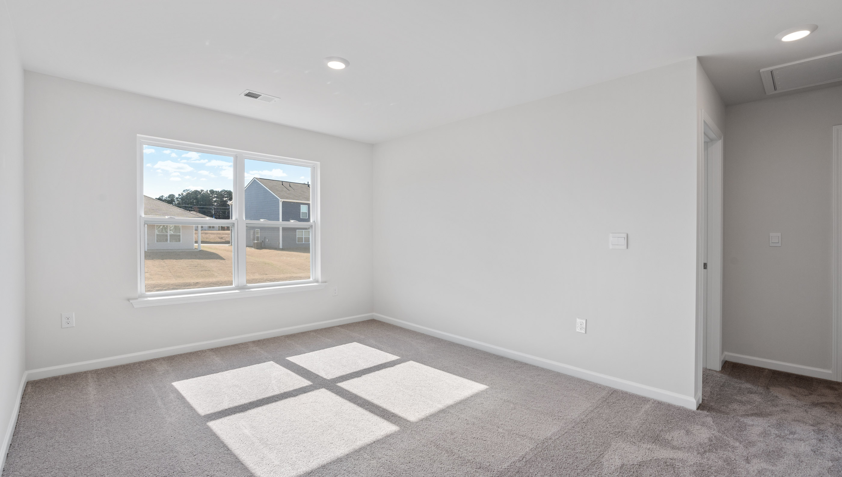Upstairs living area with carpet and windows.