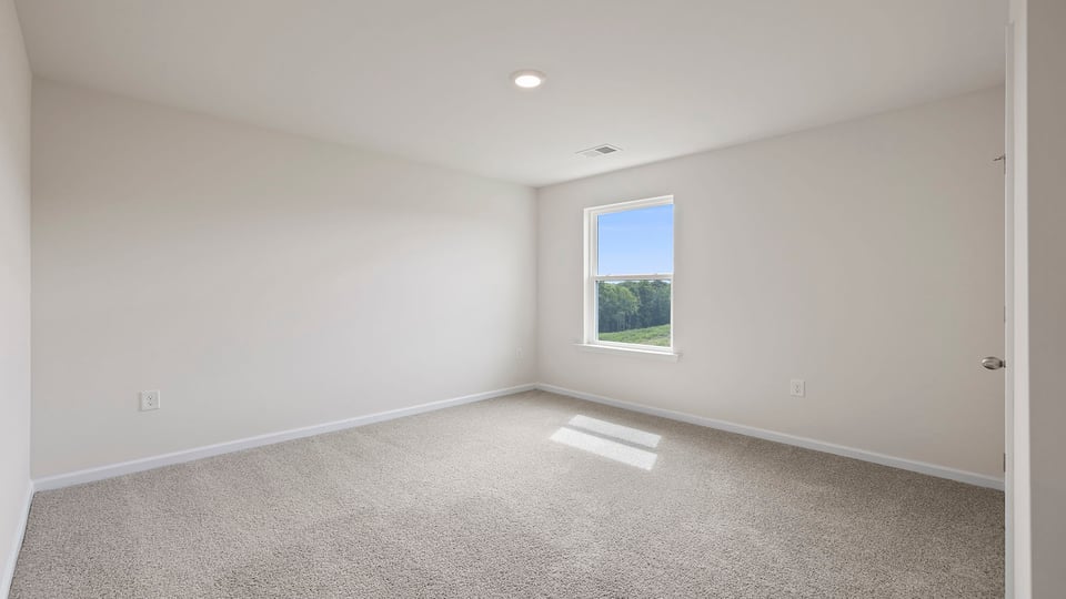 Bedroom with carpet and windows.