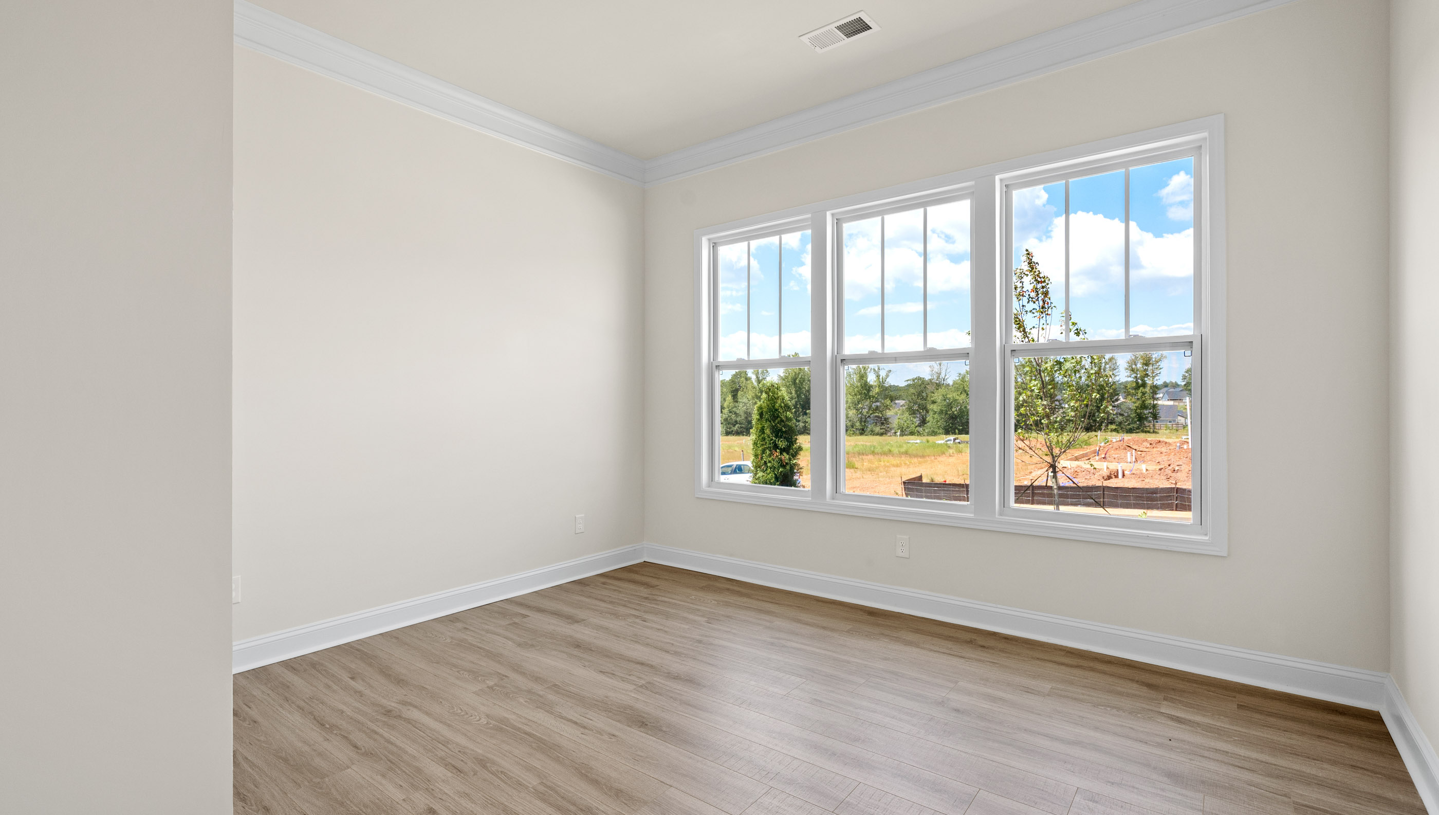 Bedroom with vinyl floors and window.