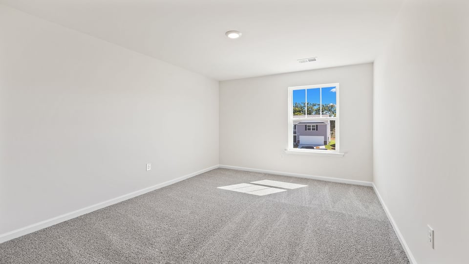 Bedroom with carpet and window.