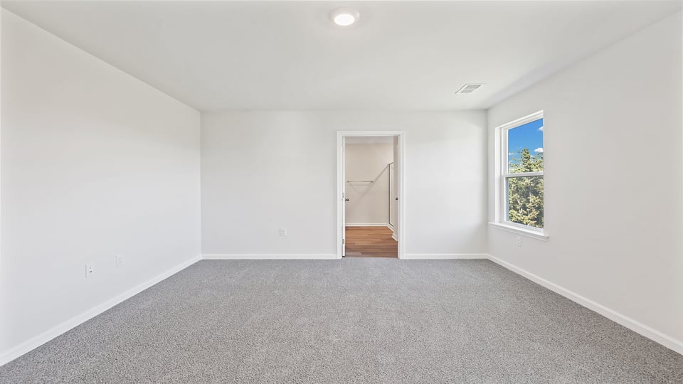 Bedroom with carpet and window.