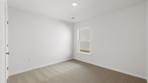 Bedroom with carpet and window.