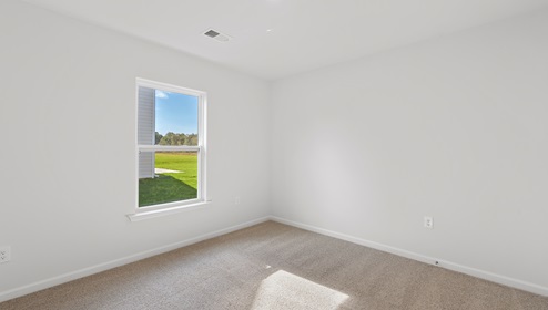 Bedroom with carpet and window.