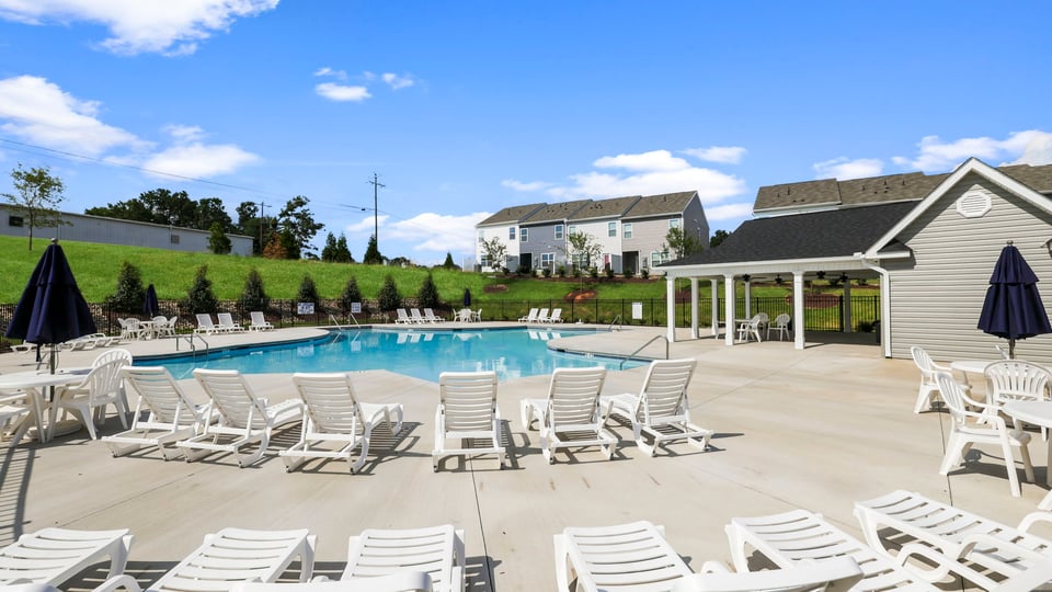Pool amenity with clubhouse and chairs.