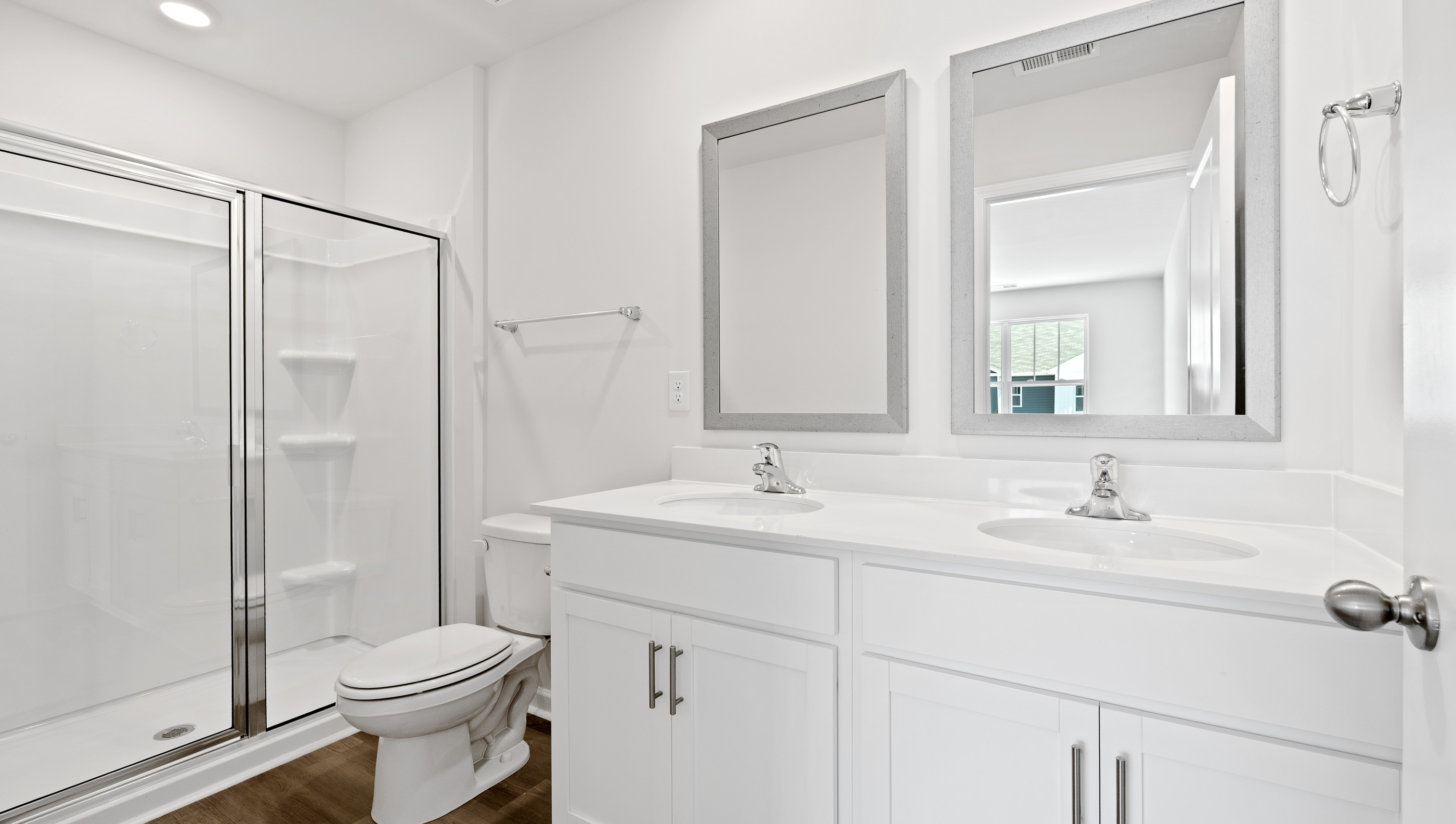 Primary bathroom with dual sink vanity and walk-in shower.