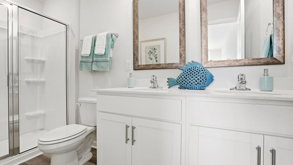 Bathroom with double vanity sink and walk in shower.