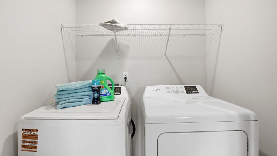 Laundry room with hanging storage racks.