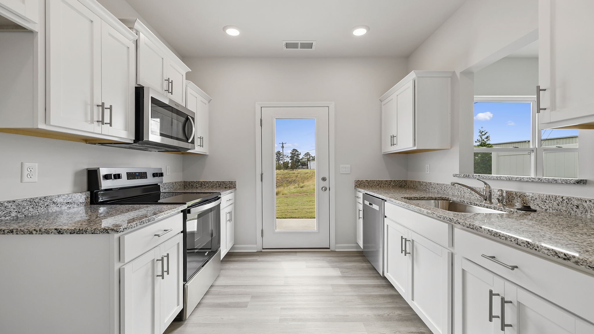 Galley kitchen with granite countertops.