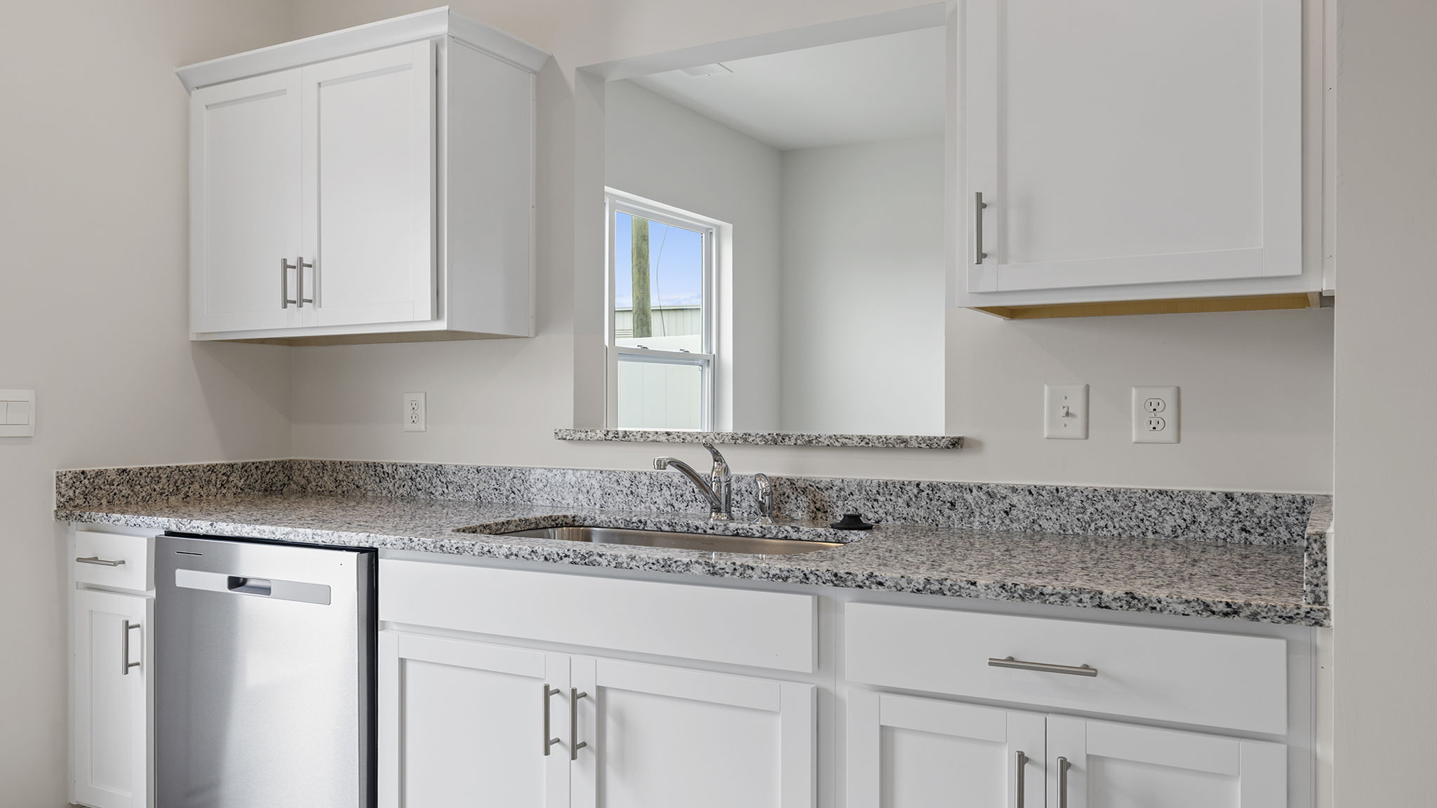 White cabinets and window into dining area.