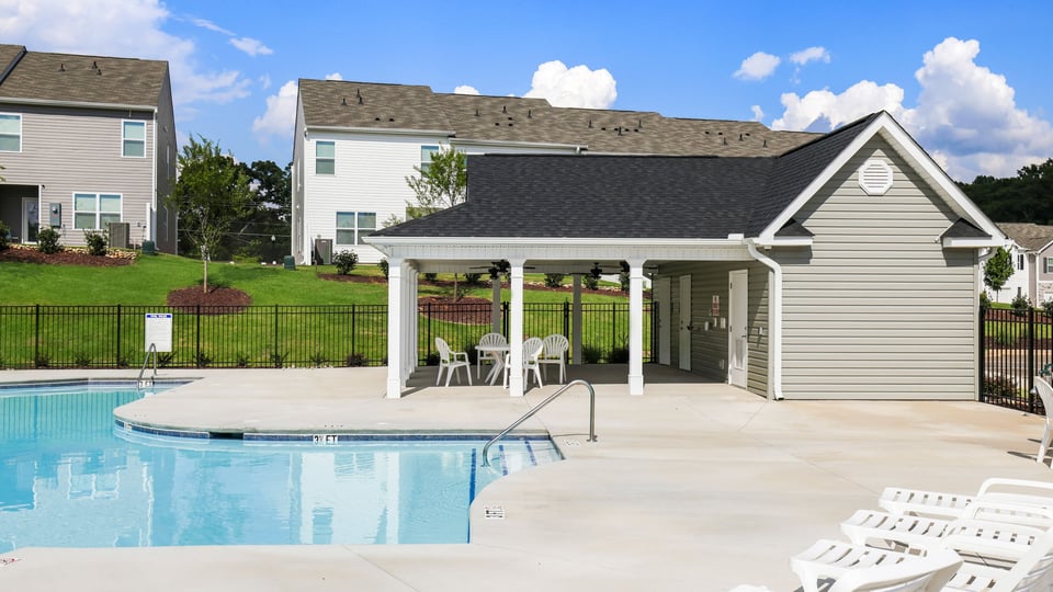 Pool amenity with clubhouse and chairs.