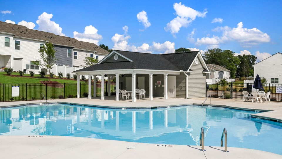 Pool amenity with clubhouse and chairs.