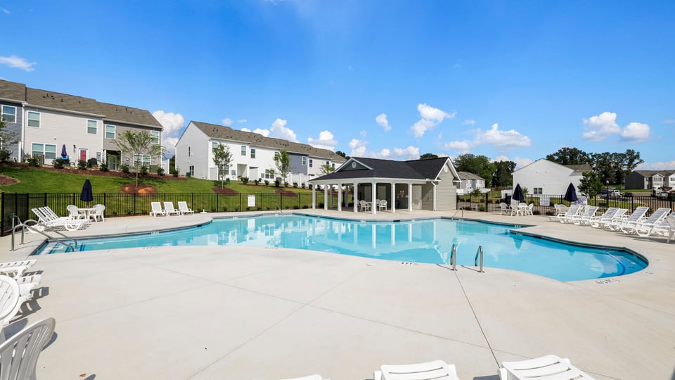 Pool amenity with clubhouse and chairs.