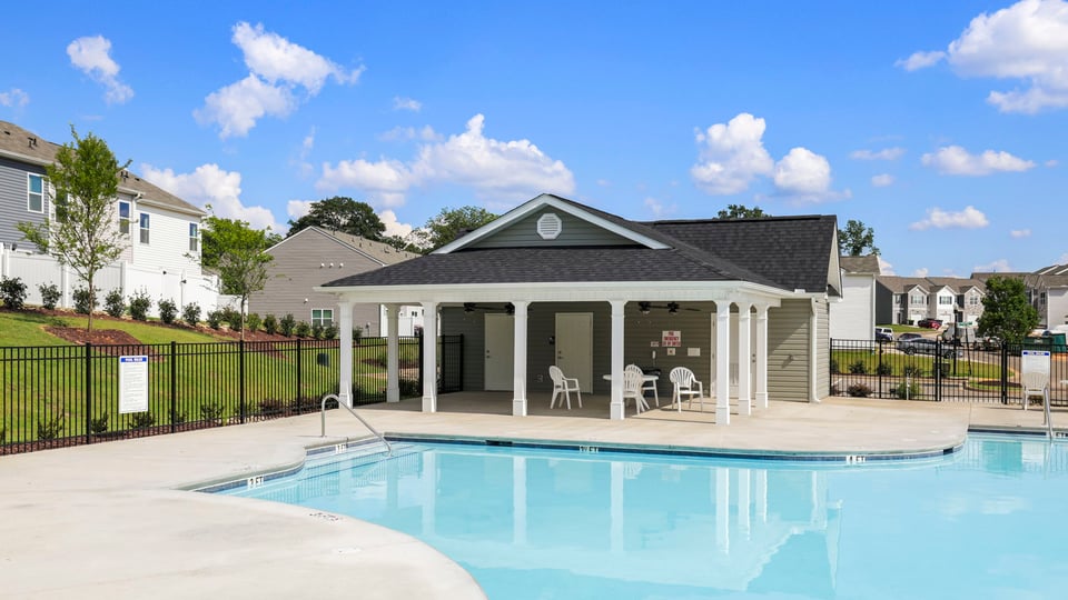 Pool amenity with clubhouse and chairs.