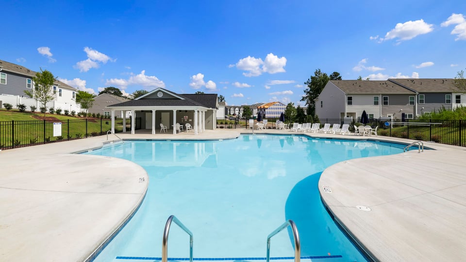 Pool amenity with clubhouse and chairs.