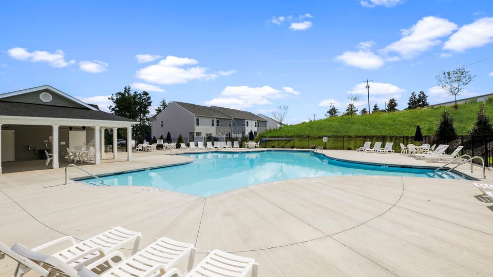 Pool amenity with clubhouse and chairs.