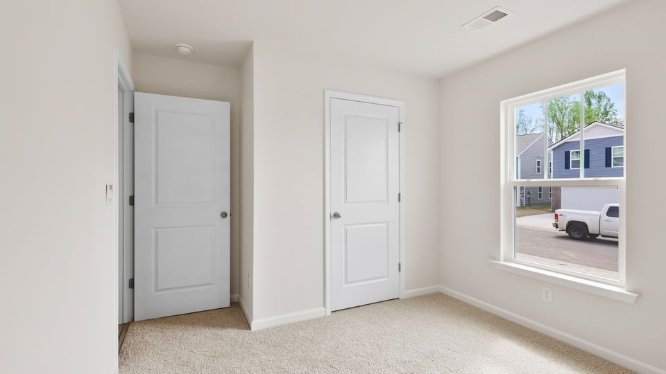 Bedroom with carpet and windows.