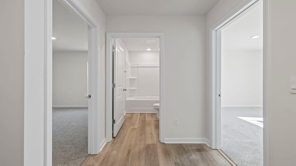View of hallway noting bath in the middle and bedrooms on either side.