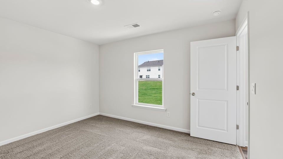 Bedroom with carpet and window.