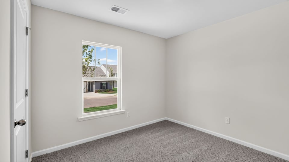 Bedroom with carpet and windows.