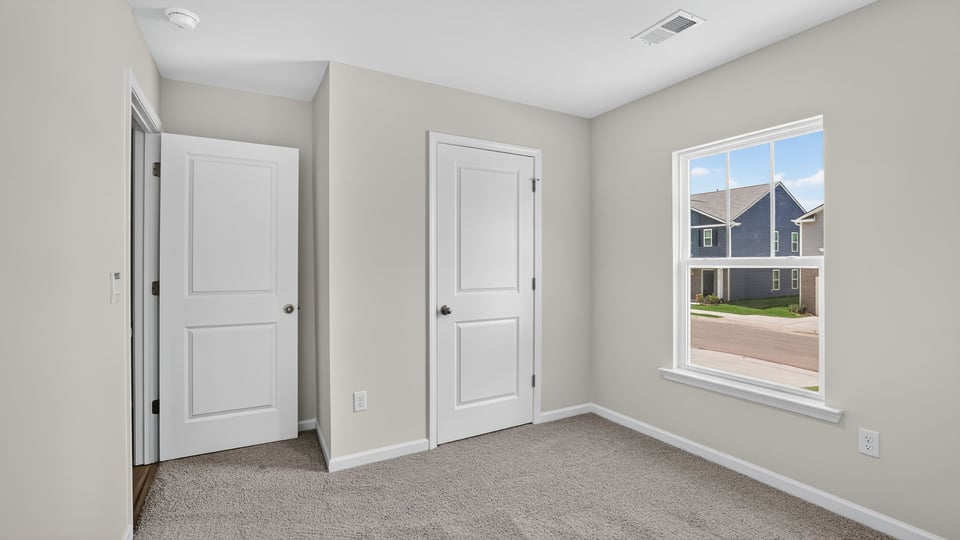 Bedroom with carpet and windows.