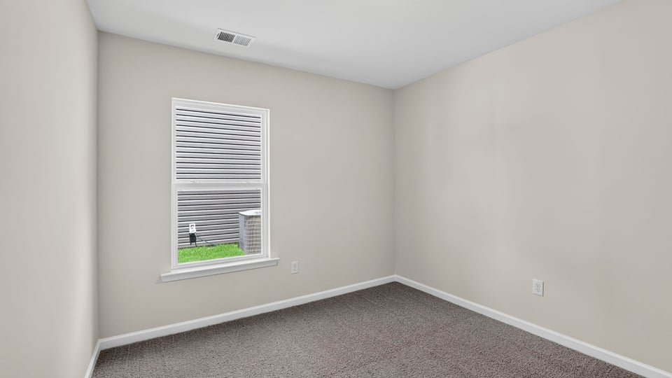 Bedroom with carpet and windows.