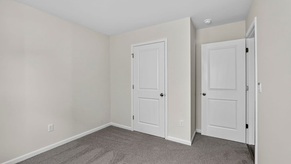 Bedroom with carpet and windows.