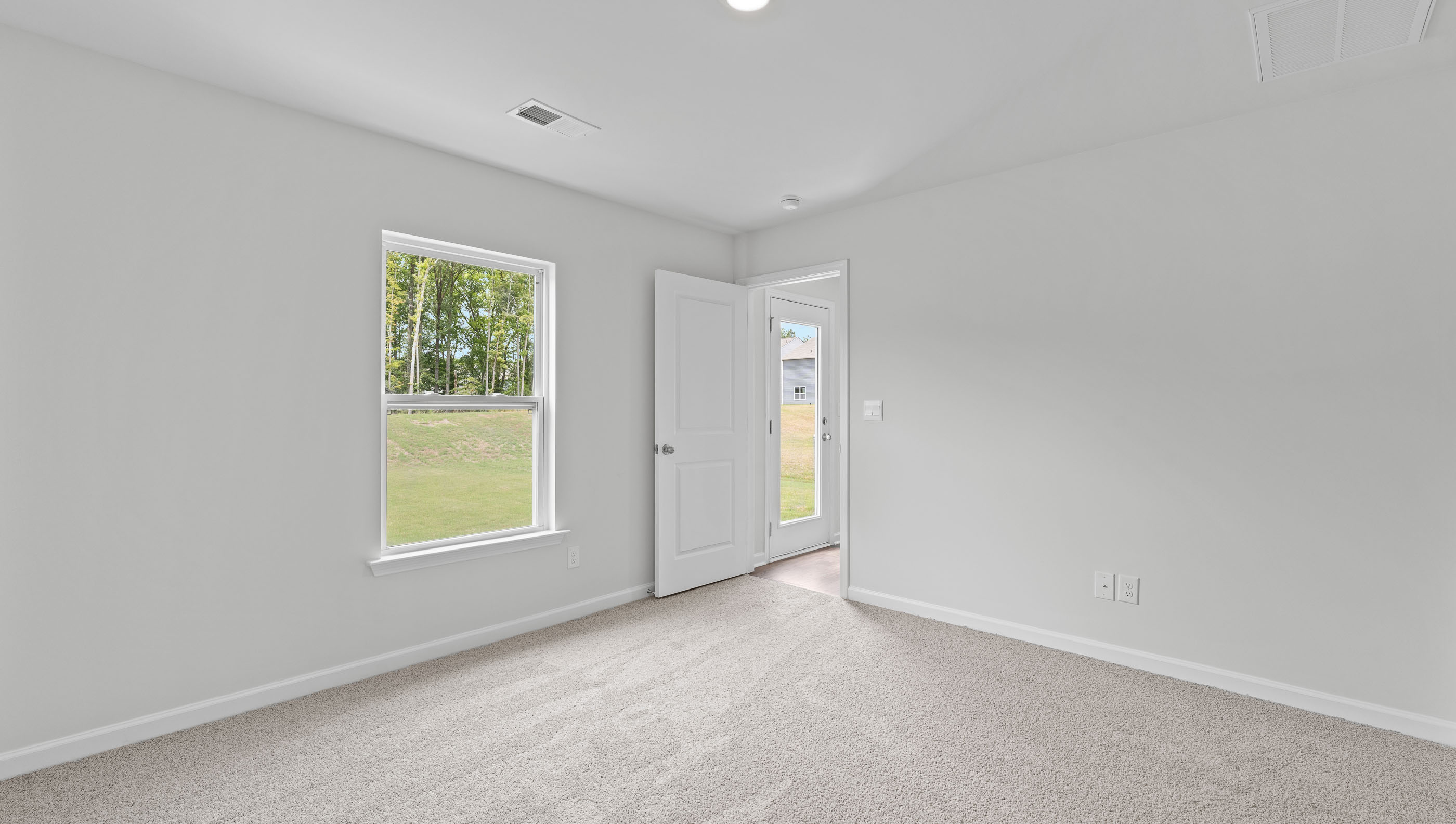 Primary bedroom with carpet and window,