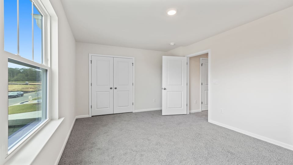 Bedroom with window and carpet.