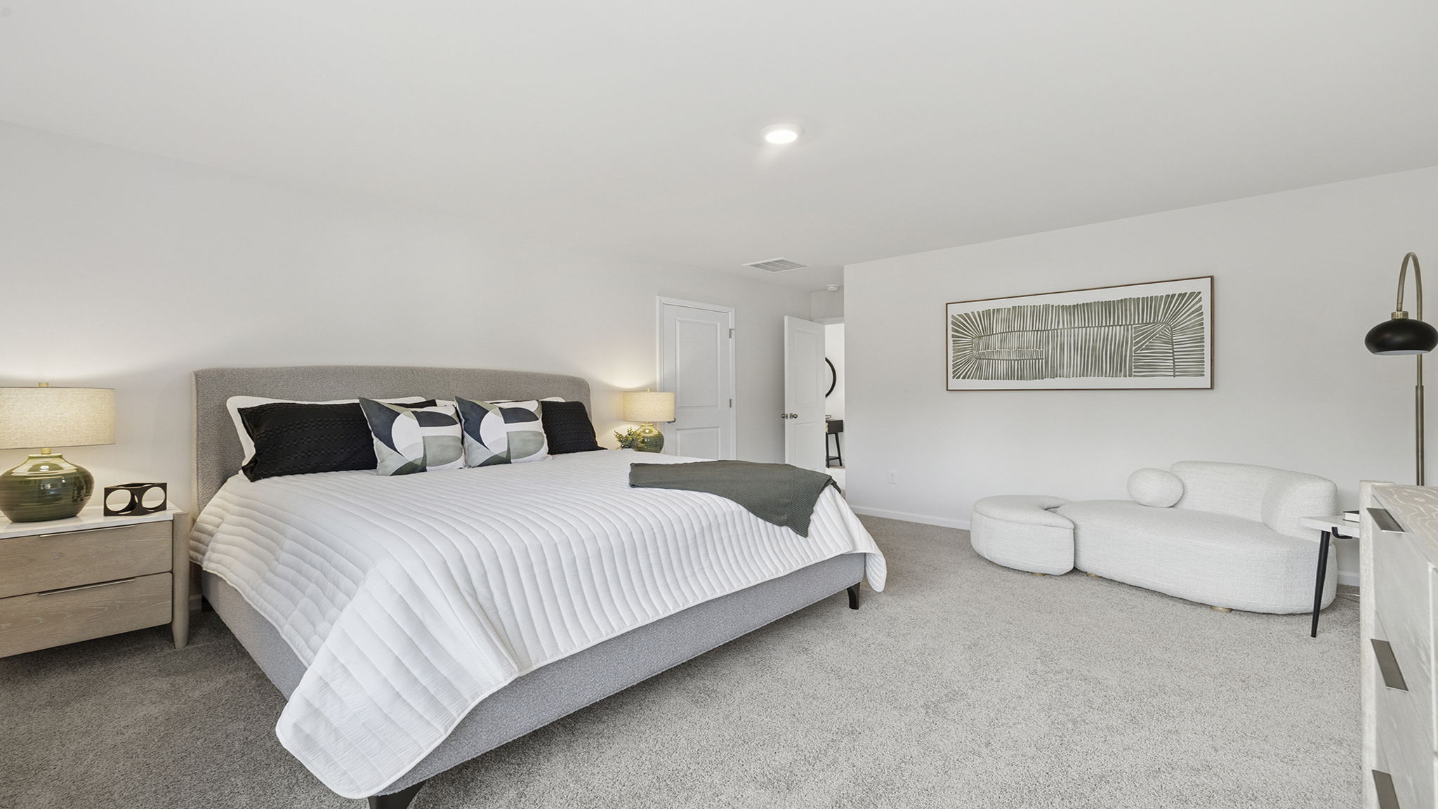 Primary bedroom with carpet and windows.