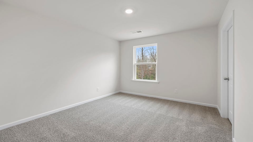 Bedroom with carpet and window.