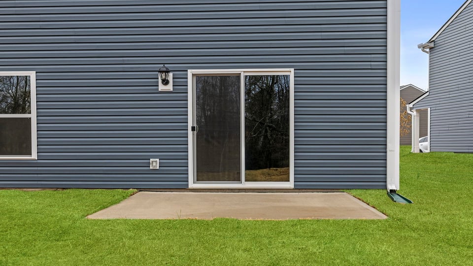 Back exterior of home with large backyard.