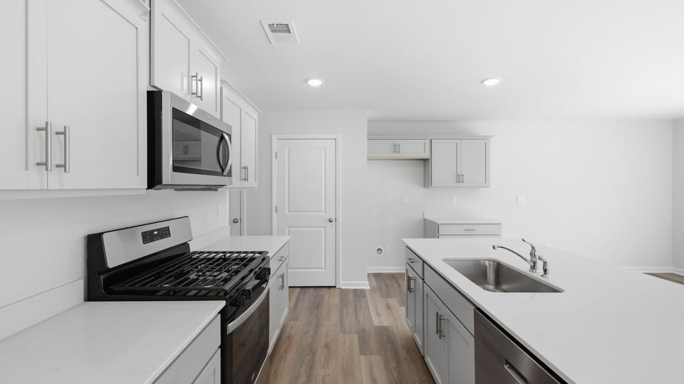 Kitchen and island with quartz countertops and stainless steel appliances.
