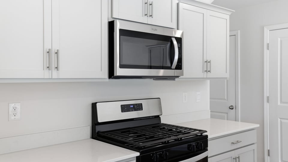 Kitchen and island with quartz countertops and stainless steel appliances.