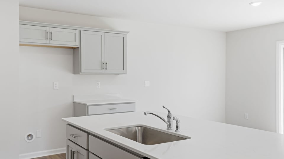Kitchen and island with quartz countertops and stainless steel appliances.