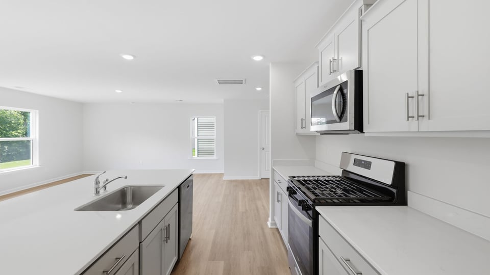 Kitchen and island with quartz countertops and stainless steel appliances.