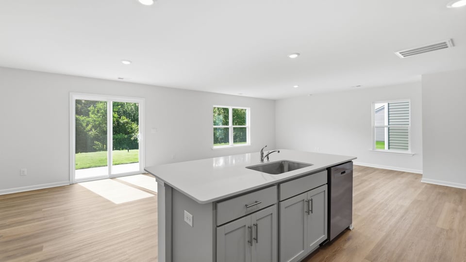 Kitchen and island with quartz countertops and stainless steel appliances.