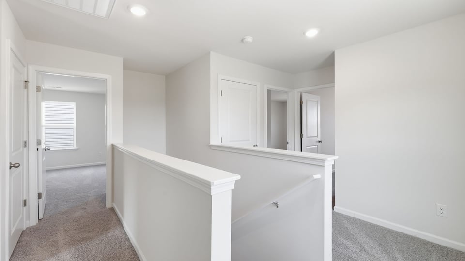 Loft area with carpet and windows.