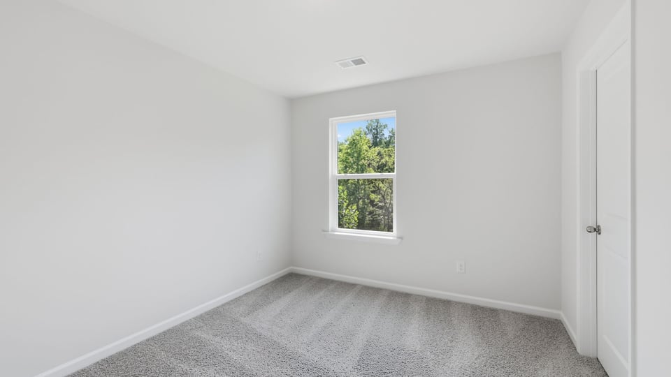 Bedroom with carpet and window.
