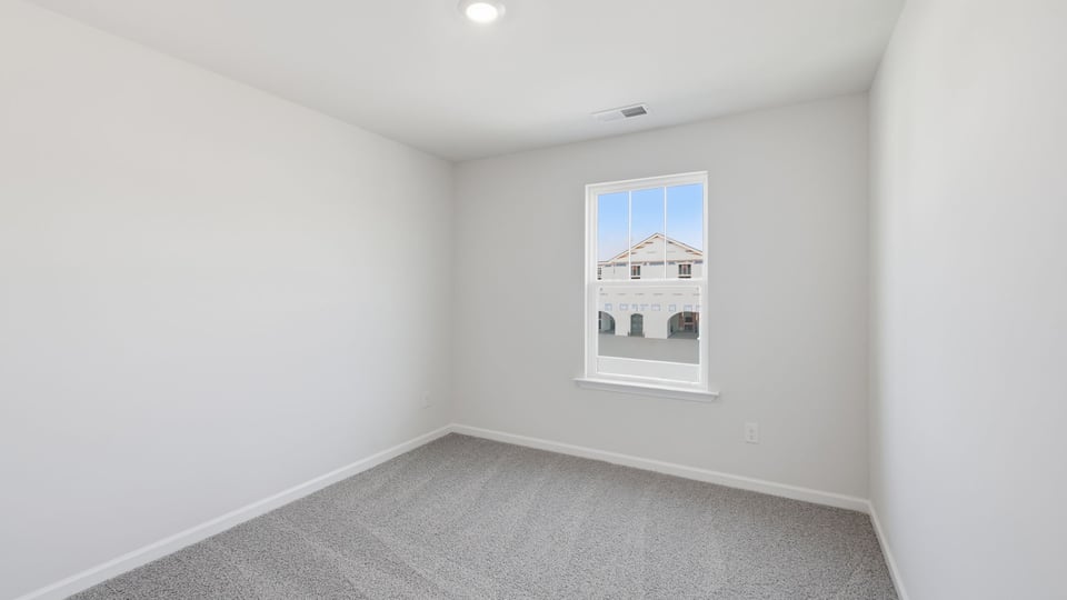 Bedroom with carpet and window.