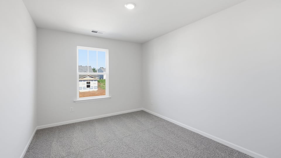 Bedroom with carpet and window.