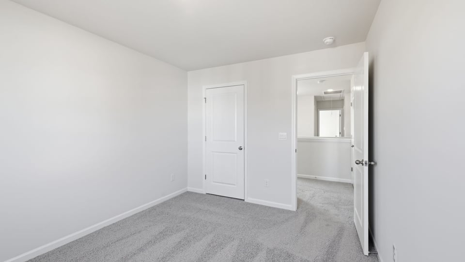 Bedroom with carpet and window.