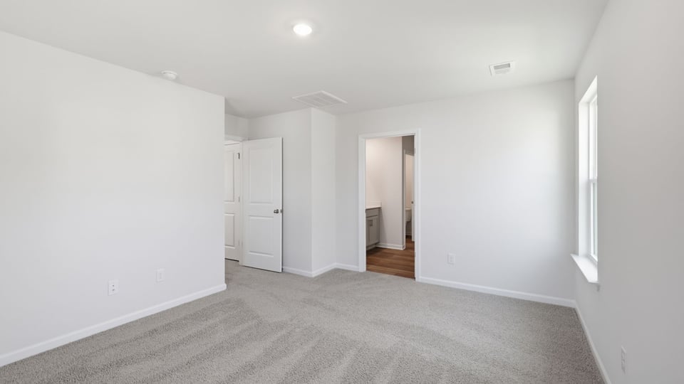 Bedroom with carpet and window.
