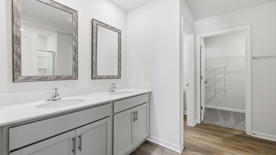 Bathroom with double vanity sink and walk in closet.
