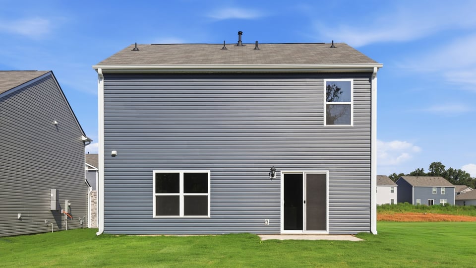 Back exterior of home with large backyard.