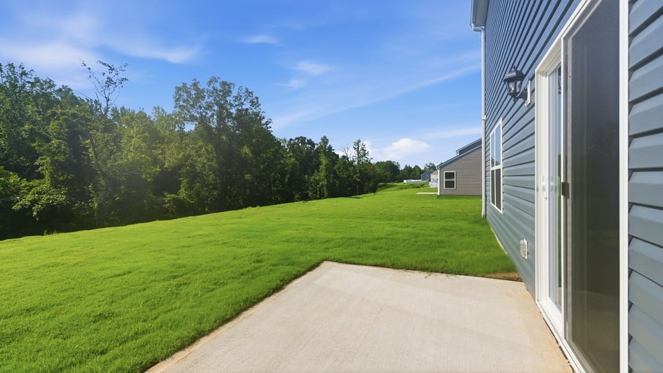 Back exterior of home with small patio.