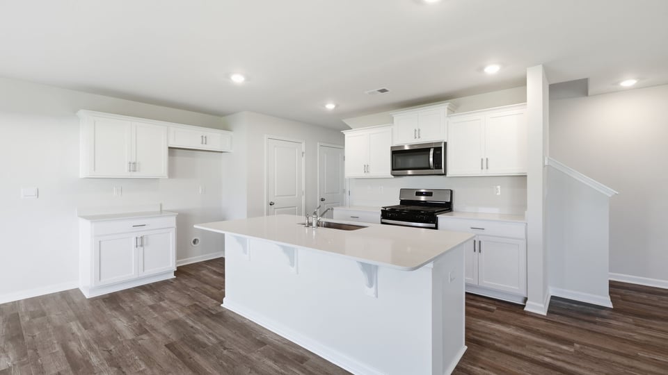 Kitchen and island with quartz countertops.