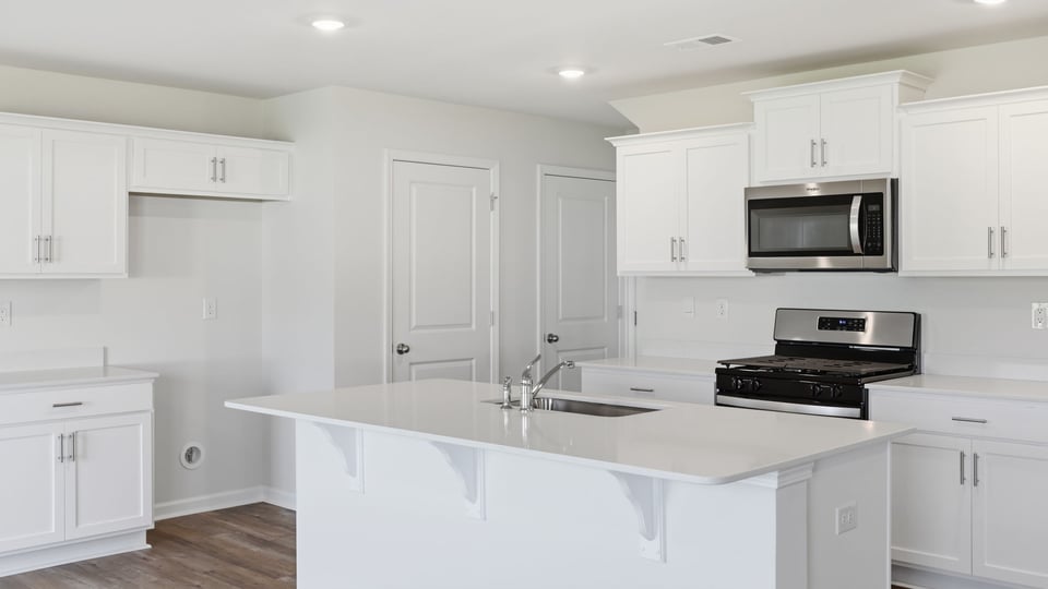 Kitchen and island with quartz countertops.