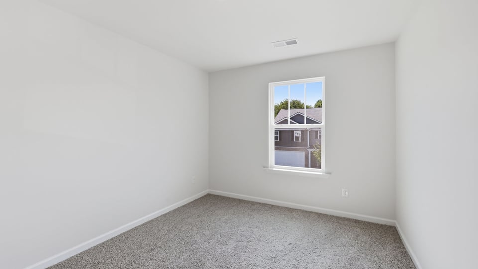 Bedroom with carpet and window.