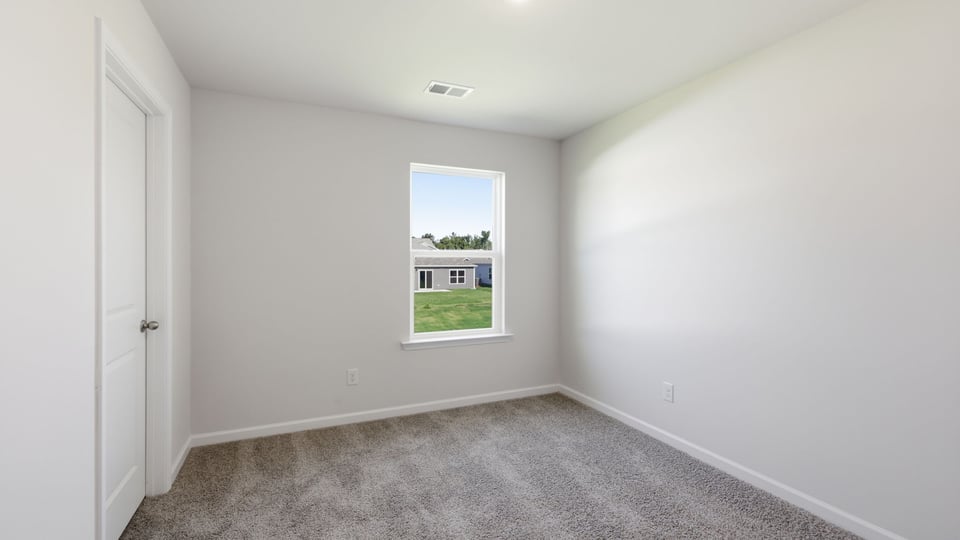 Bedroom with carpet and window.